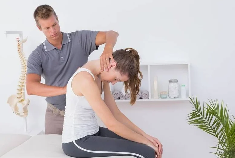 A chiropractor treating the neck of a woman.
