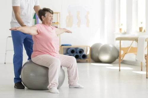 iStock-859647434_super-min-768×512 An elderly woman having help with some exercises.