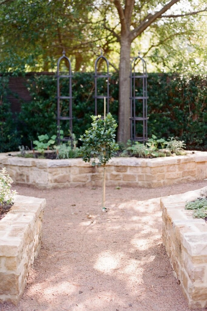 Πέτρινα παρτέρια κήπου με χώμα και κεντρικό μονοπάτι