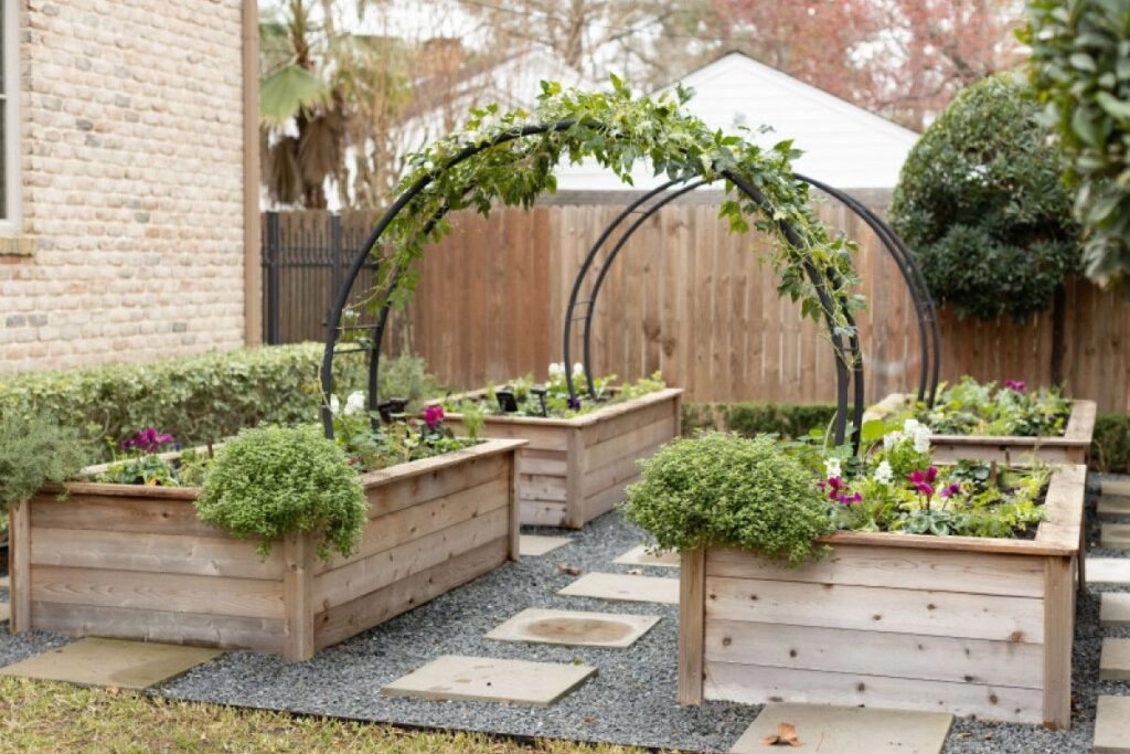 Ξύλινα παρτέρια κήπου με μεταλλική καμάρα και λουλούδια