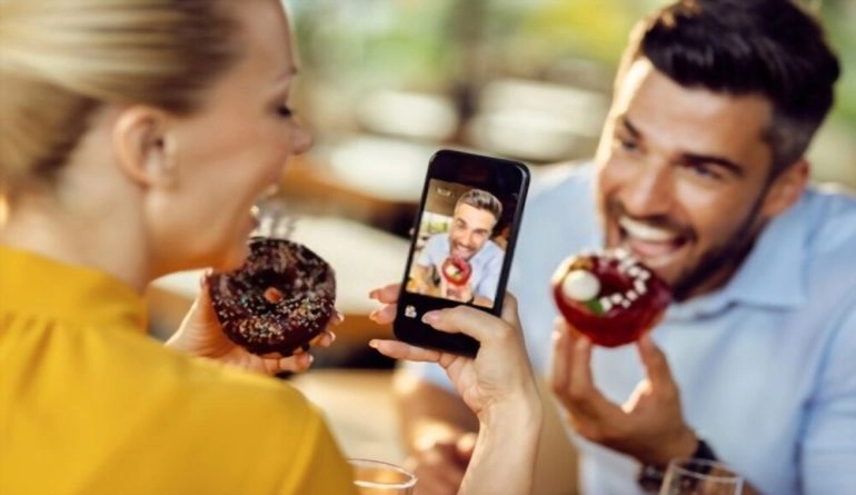 Επέτειος γάμου: 9 ιδέες για να γιορτάσετε την αγάπη σας 7 Ζευγάρι που τραβάει βίντεο τρώγοντας ντόνατς