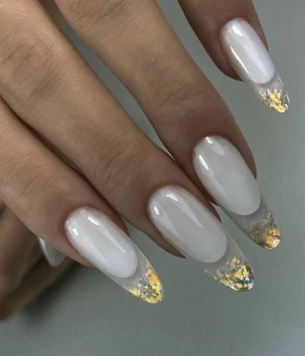 Νύχια για νύφη με λευκή βάση και χρυσό και ασημί foil στις άκρες, σε σχήμα αμυγδάλου.