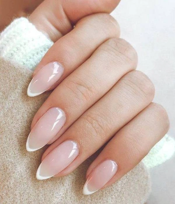 Νυφικά νύχια με γαλλικό μανικιούρ και αμυγδαλωτό σχήμα, σε φυσική απόχρωση με λεπτή λευκή γραμμή.