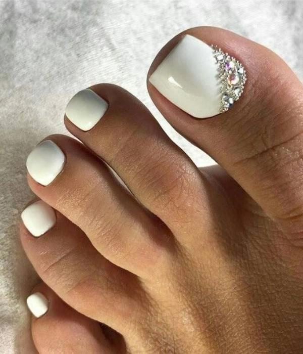 Νυφικά νύχια ποδιών με λευκό χρώμα και στρας, σε τετράγωνο σχήμα, ιδανικά για την ημέρα του γάμου.