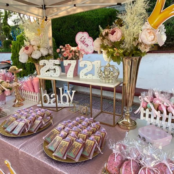 Στολισμός βάπτισης εμπνευσμένος από βασιλικά παραμύθια, με στέμματα, τούλια και χρυσές λεπτομέρειες σε παστέλ φόντο.