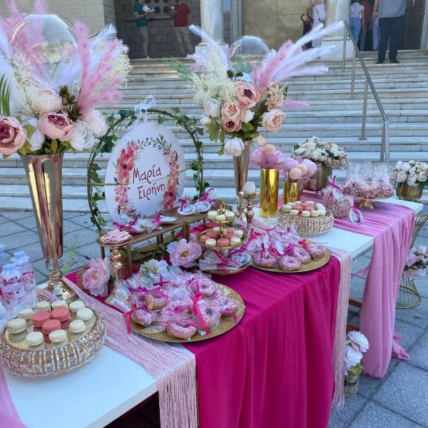 Διακόσμηση βάπτισης με φυσικά λουλούδια, γιρλάντες και παστέλ αποχρώσεις, ιδανική για ανοιξιάτικη ή καλοκαιρινή τελετή.