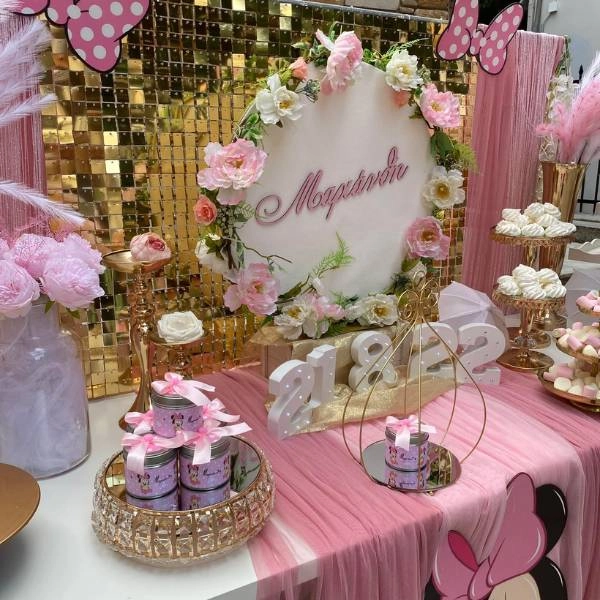 Διακόσμηση βάπτισης με θέμα Minnie Mouse, σε ροζ-λευκές αποχρώσεις, με φιόγκους, παγιέτες και χρυσά διακοσμητικά.