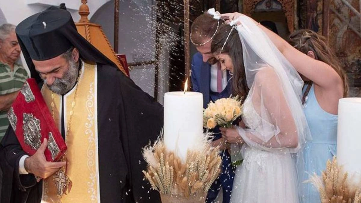 Έξοδα κουμπάρου και υποχρεώσεις | Τι πληρώνει στο γάμο; 1 Η κουμπάρα αλλάζει τα στέφανα σε παραδοσιακό ελληνικό γάμο, δίπλα σε λαμπάδες και ιερέα – έξοδα και υποχρεώσεις κουμπάρου