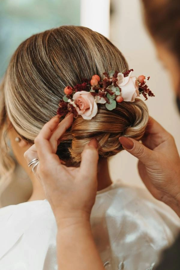 Κλασικός χαμηλός κότσος με floral διακόσμηση σε ροζ αποχρώσεις