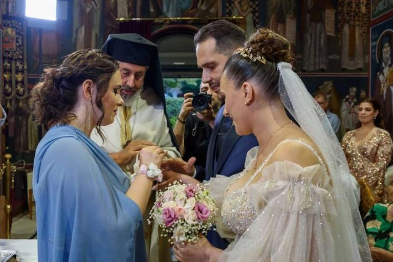 Έξοδα κουμπάρου και υποχρεώσεις | Τι πληρώνει στο γάμο; 8 Στιγμιότυπο από γάμο όπου η κουμπάρα βάζει τη βέρα στον γαμπρό μπροστά στον ιερέα και τη νύφη