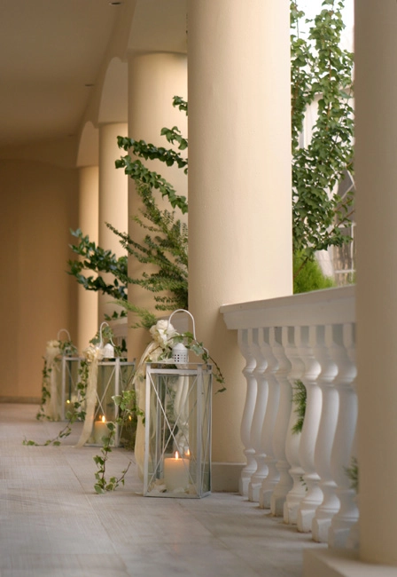 Ρομαντικός στολισμός με φαναράκια και πρασινάδα σε στοά δεξίωσης γάμου, διακόσμηση από τη Vassiliki Creations στο Golf Γλυφάδας