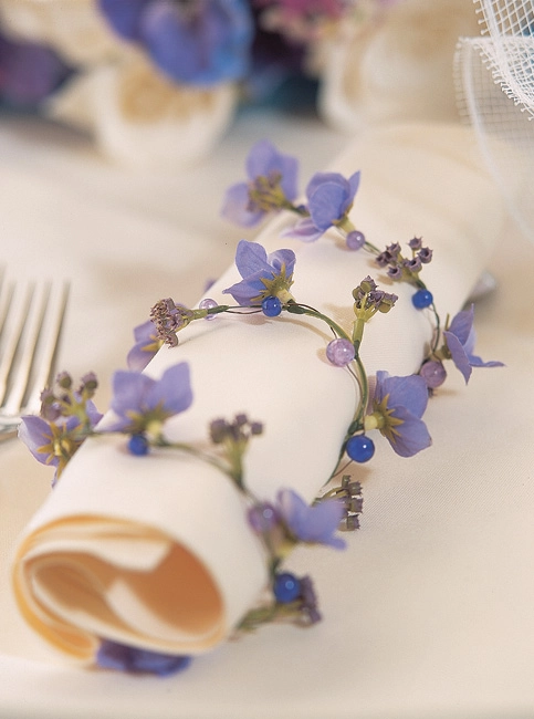 Λεπτομέρεια από πετσέτα γάμου δεμένη με στεφανάκι από μωβ λουλούδια και χάντρες, elegant στολισμός από τη Vassiliki Creations στο Mythos