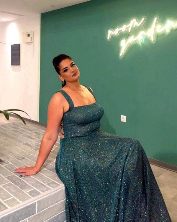 Καλεσμένη σε γάμο με εντυπωσιακό μακιγιάζ και πράσινο λαμπερό φόρεμα σε εσωτερικό χώρο