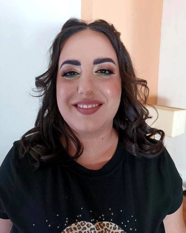 Καλεσμένη μελαχρινή σε γάμο με πράσινη σκιά και ζεστούς τόνους μακιγιάζ