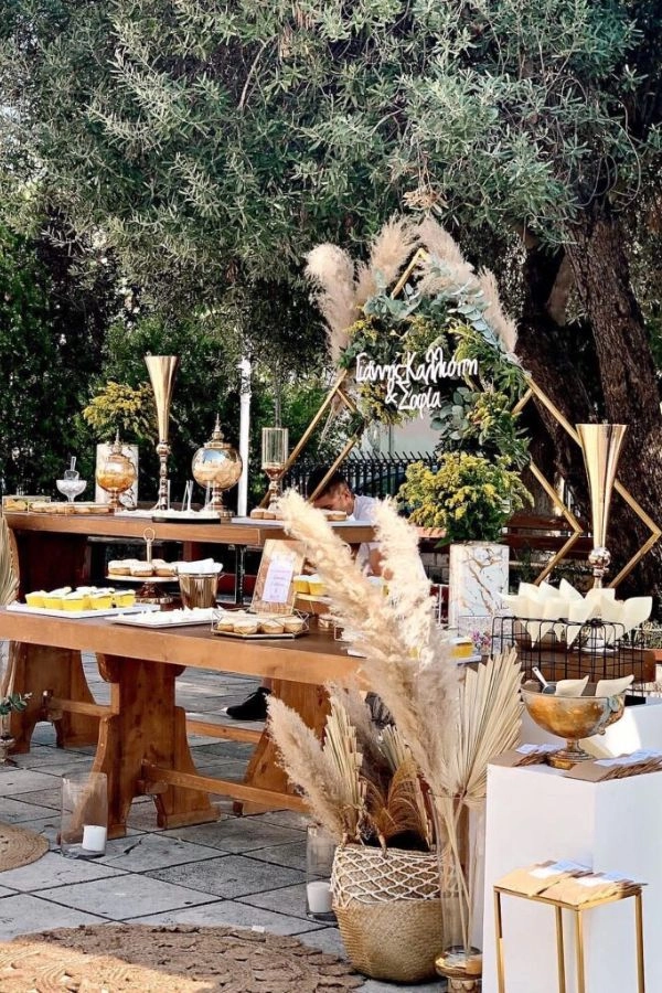 Boho στολισμός εκκλησίας στον προαύλιο χώρο με pampas, ξύλινα τραπέζια, ψάθινα καλάθια και γήινη παλέτα.