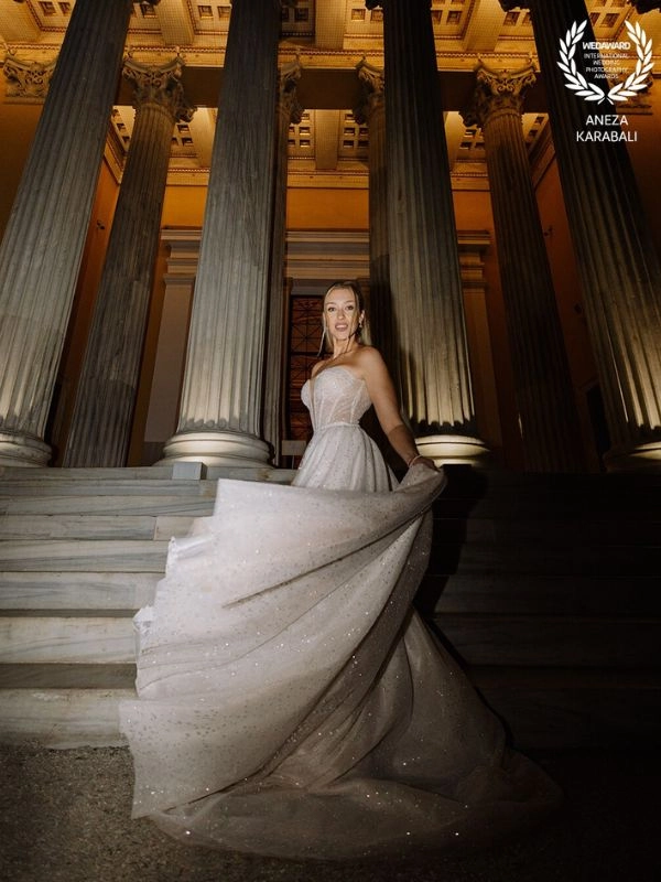 Πορτρέτο νύφης σε σκαλιά νεοκλασικού κτιρίου με εντυπωσιακό νυφικό