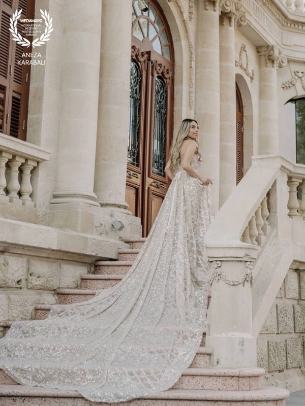 Νύφη σε σκάλα αρχοντικού με μακρύ κομψό νυφικό