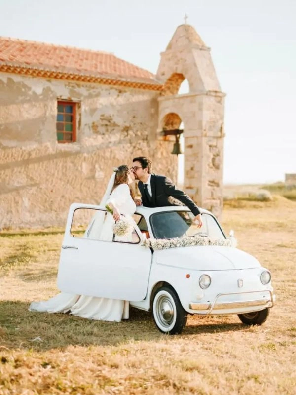 Νύφη και γαμπρός με κλασικό Fiat 500 έξω από εκκλησία την ημέρα του γάμου