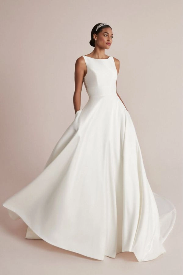 Σατέν νυφικό με κλειστή λαιμόκοψη σε φαρδιά γραμμή και με ανοιχτή πλάτη σε σχήμα V.